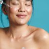 woman using serum on her face